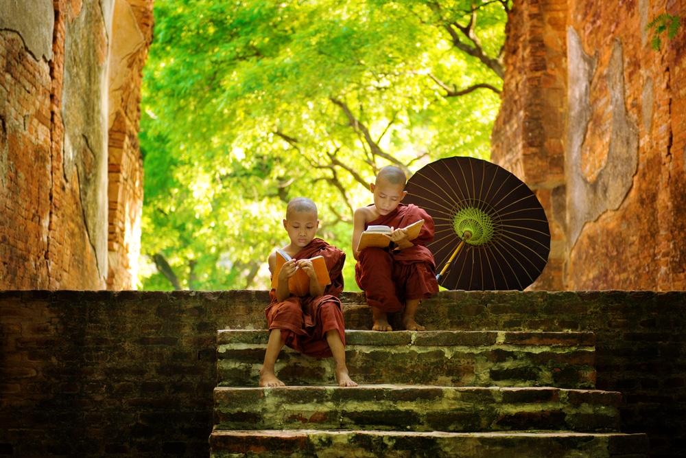 Young-Buddhist-monk-reading-outdoors-sitting-outside-monastery-Myanmar.jpg