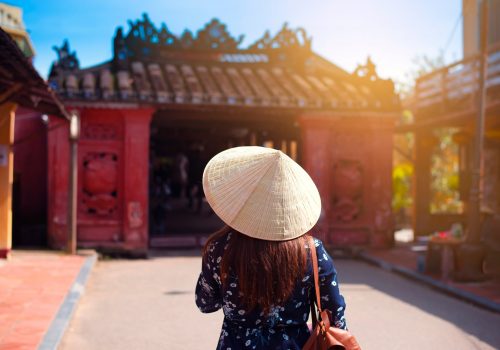 Woman-tourist-is-wearing-Vietnamese-Hat-Non-La-and-traveling-in-Hoi-An-old-town-in-Vietnam